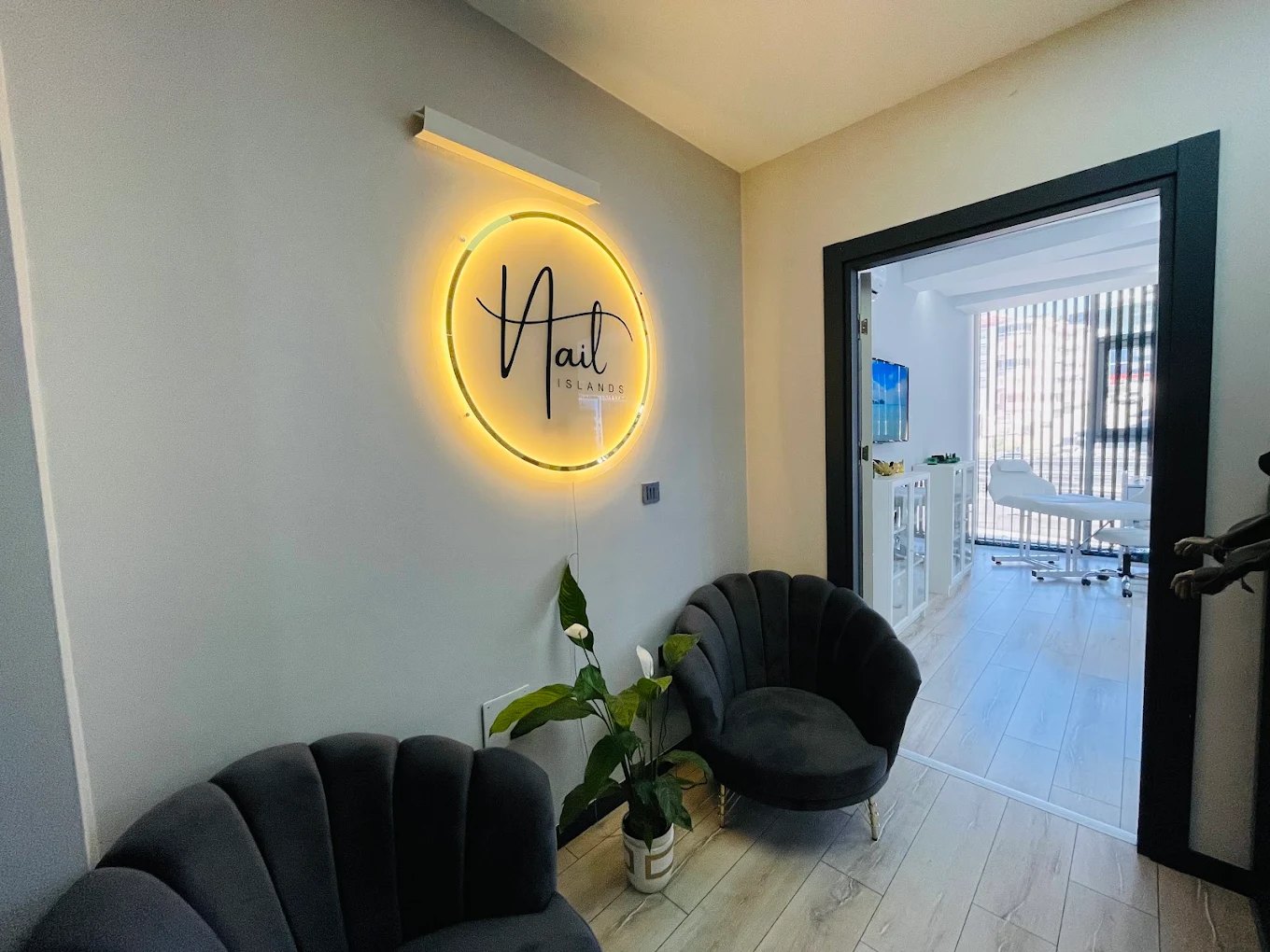 Nail Islands Kuşadası karşılama alanı: ışıklı logo ve bekleme koltukları